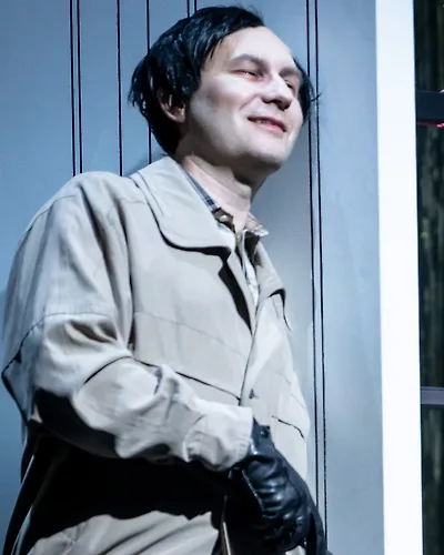 Semjon Bulinsky als Delbert Grady in Moravecs „The Shining“, schwarze Perücke und weiß geschminktes Gesicht, mit schwarzem Handschuh und Golfschläger an der Wand