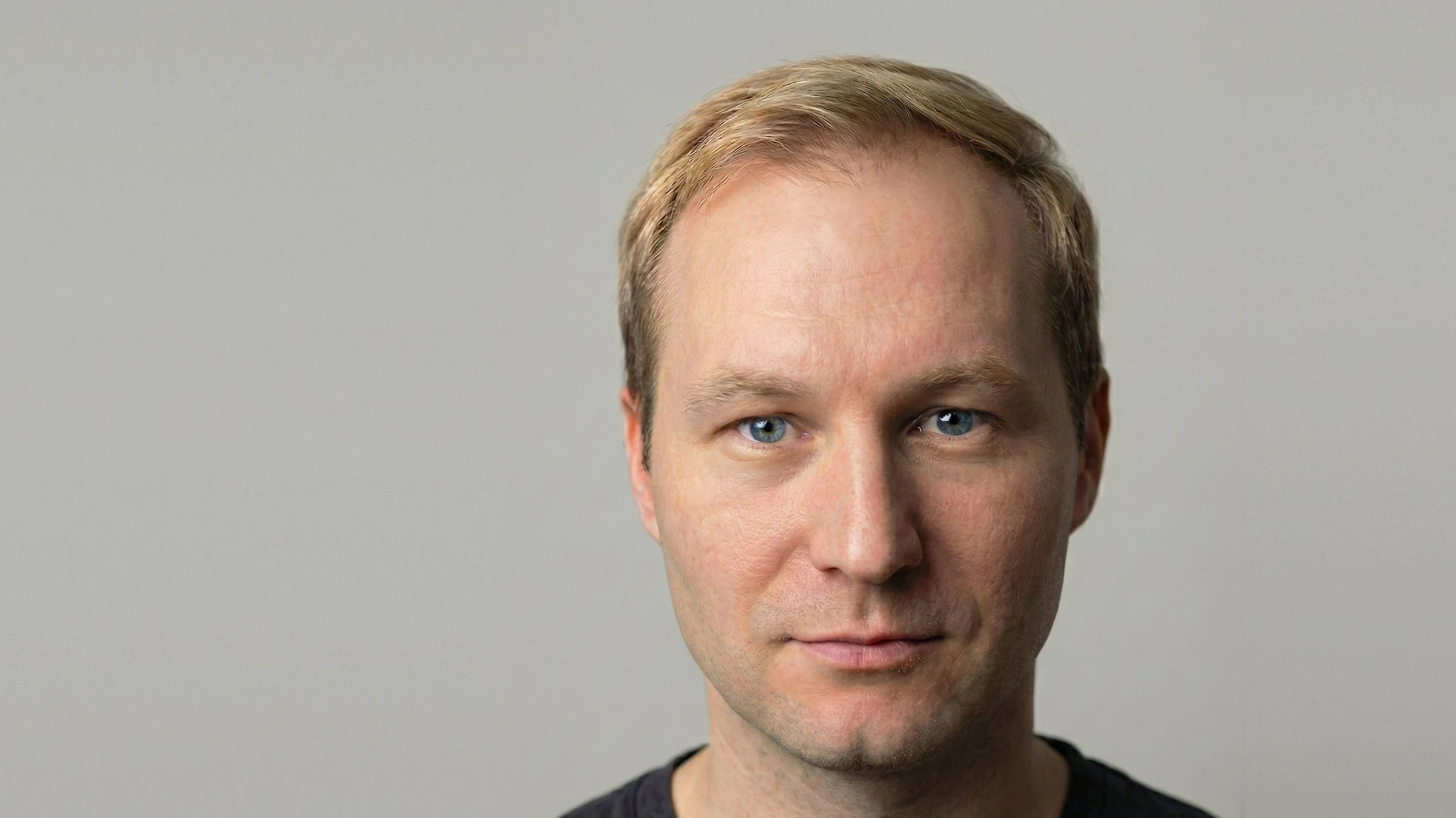 Porträt von Semjon Bulinsky vor grauem Studiohintergrund, frontal in die Kamera
