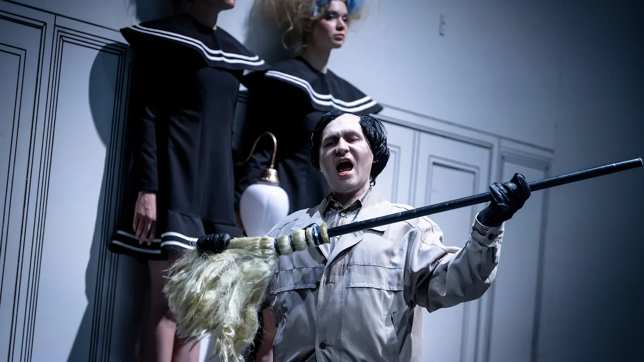 Semjon Bulinsky als Delbert Grady in Moravecs „The Shining“, schwarze Perücke und weiß geschminktes Gesicht, im Schrei, Staubwedel und Stock in den Händen